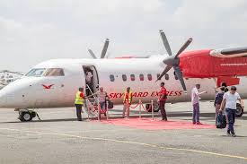 Passengers boarding a Skyward Express Dash 8 turboprop on the apron