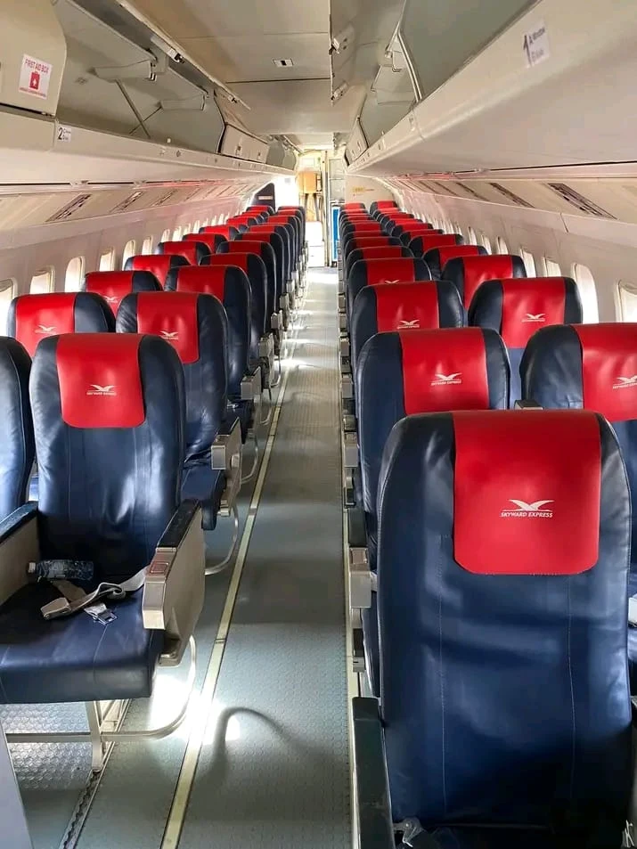 Skyward aircraft cabin with navy seats, red branded headrests and overhead luggage bins